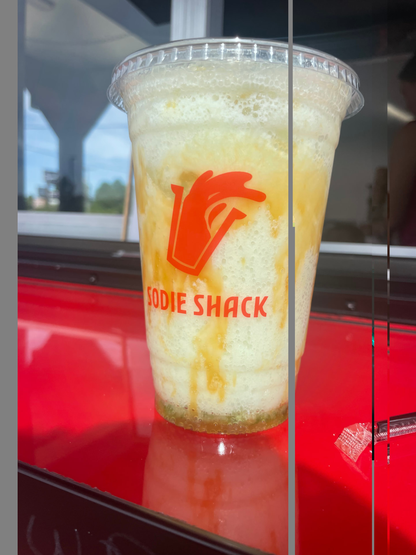 Frothy creamy soda with caramel drizzled down the cup